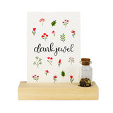 Bedankje zaden in glazen flesje met kaart in standaard